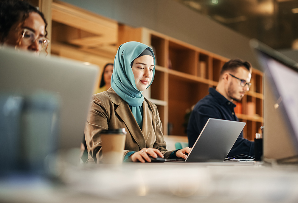 Portrait,Of,Focused,Muslim,Woman,Using,Laptop,In,A,Contemporary